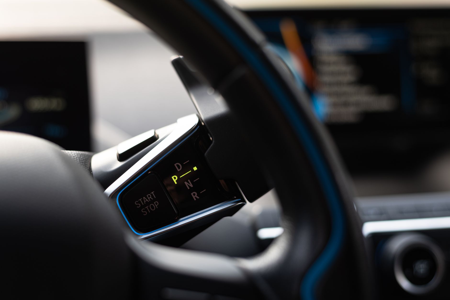 Close-up of a modern car's gear shifter and dashboard, showcasing technology and design.