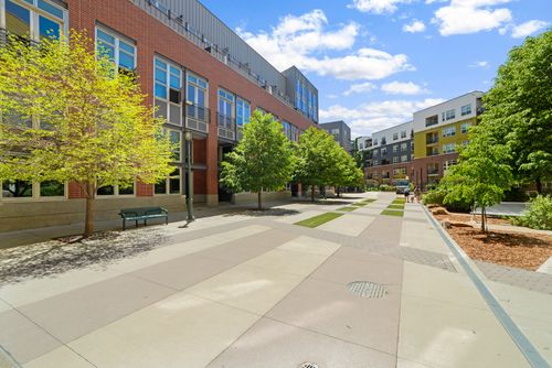 Free Contemporary urban plaza with modern buildings and trees in a sunny setting. Stock Photo