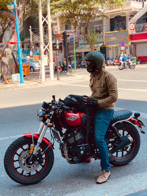 Man in Helmet Riding Motorcycle on City Street