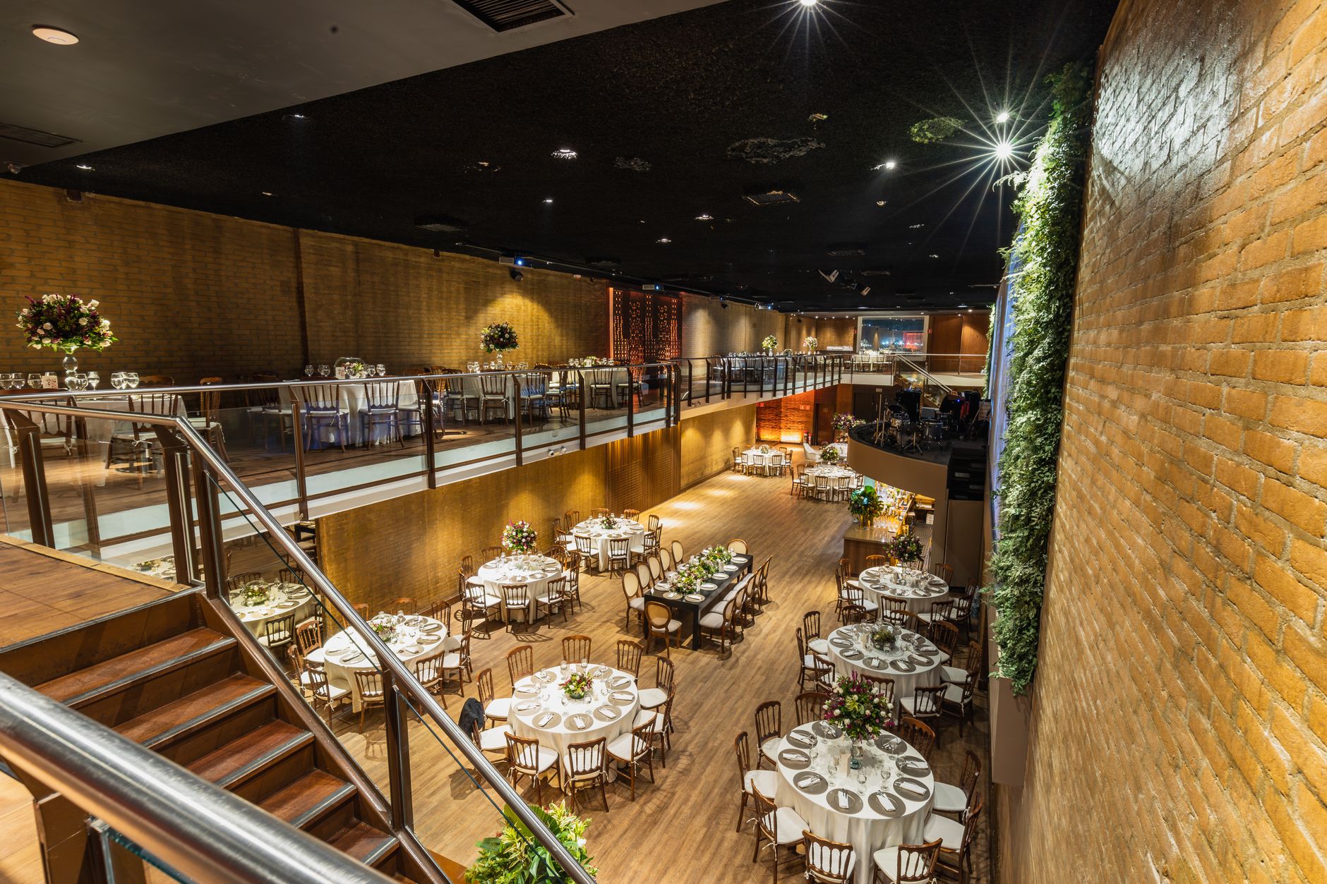 Spacious and elegantly decorated wedding reception venue with floral table settings.