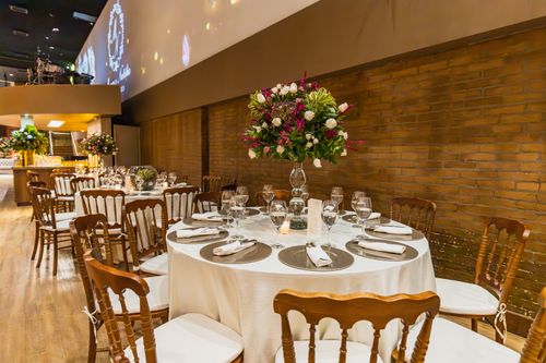 Free Luxurious indoor dining setup with decorated tables for a wedding reception. Stock Photo