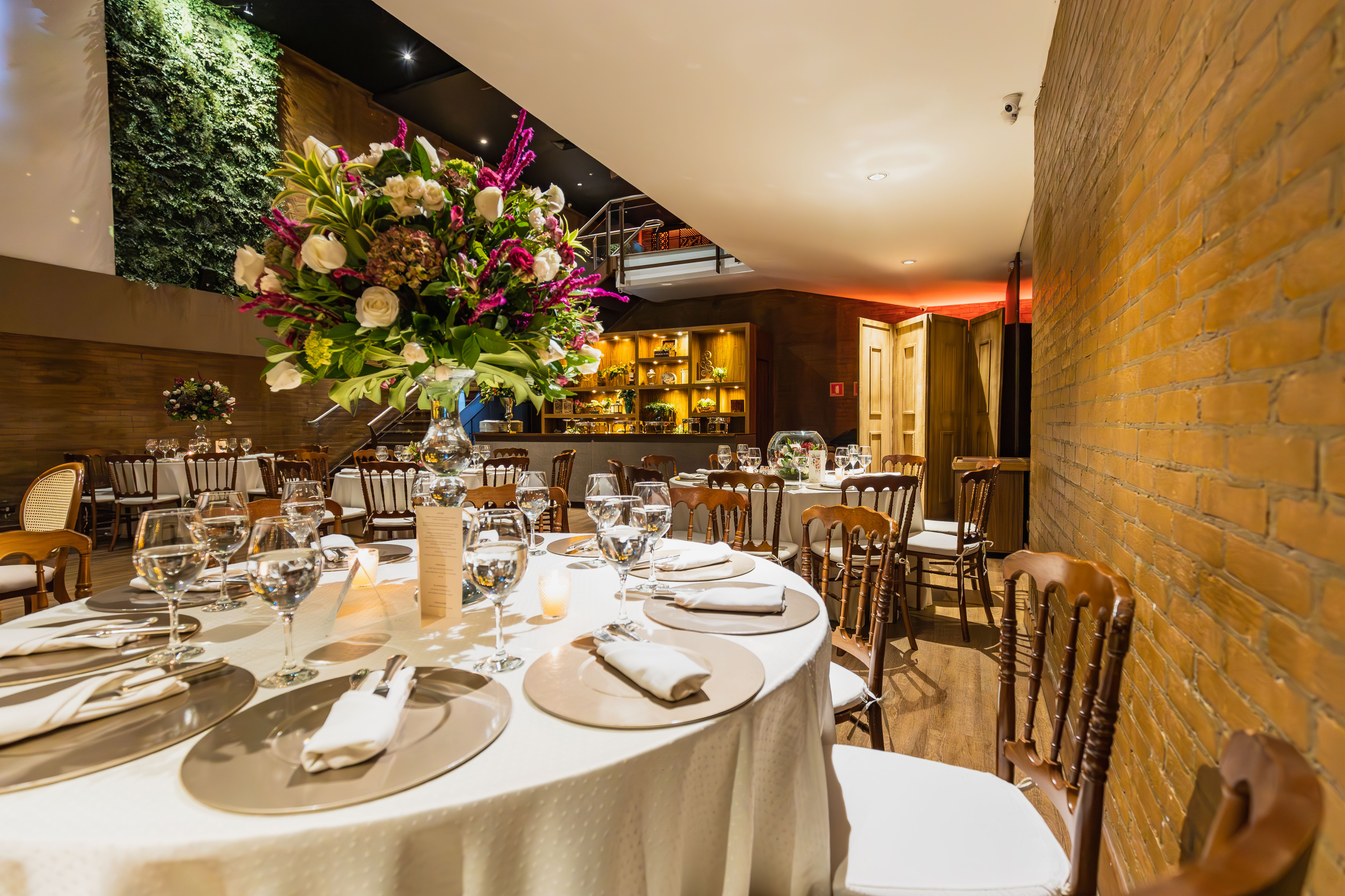 Luxurious indoor wedding reception with elegant table setting and vibrant floral arrangements.