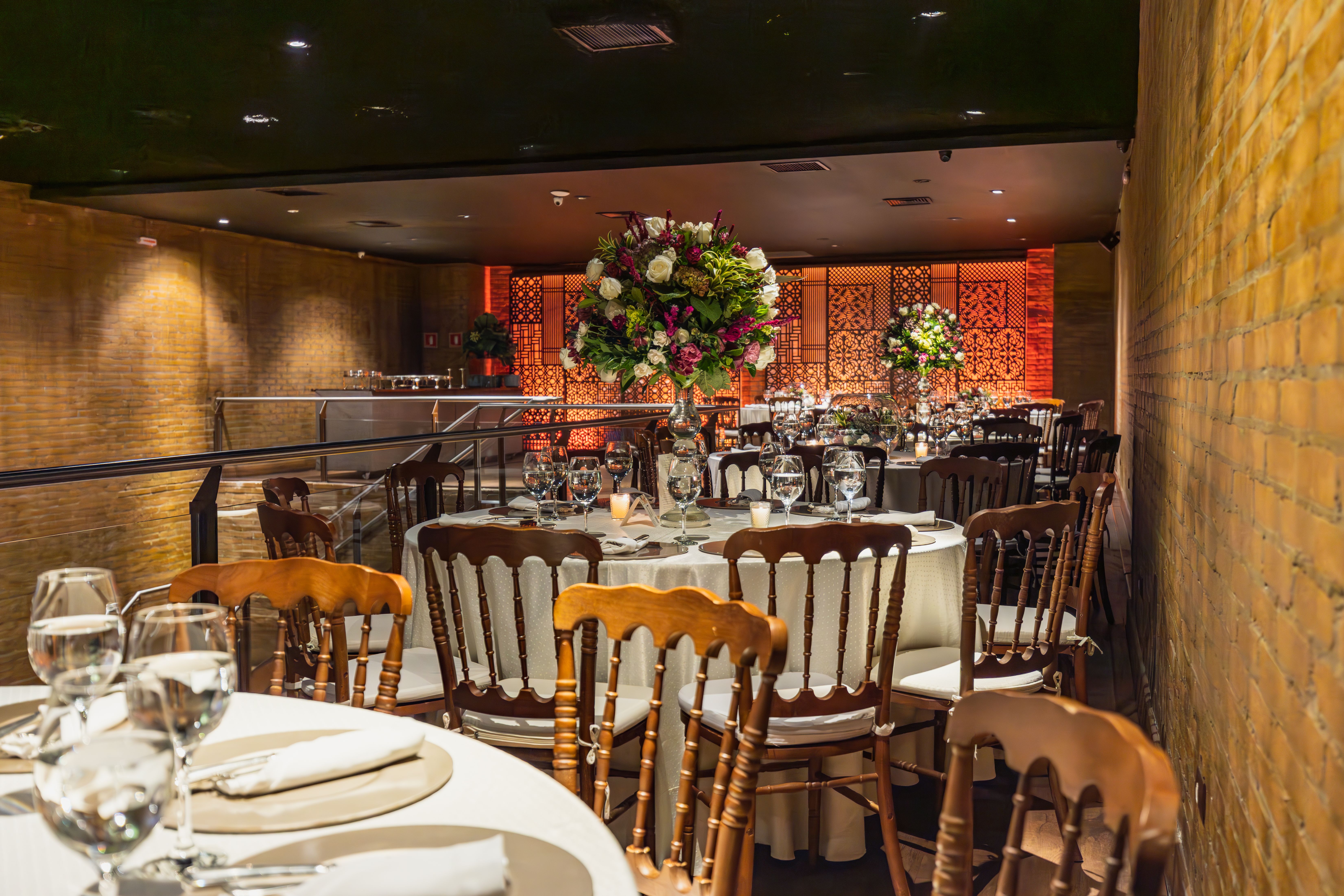 Luxurious wedding reception with ornate floral centerpieces and elegant tableware in an indoor setting.