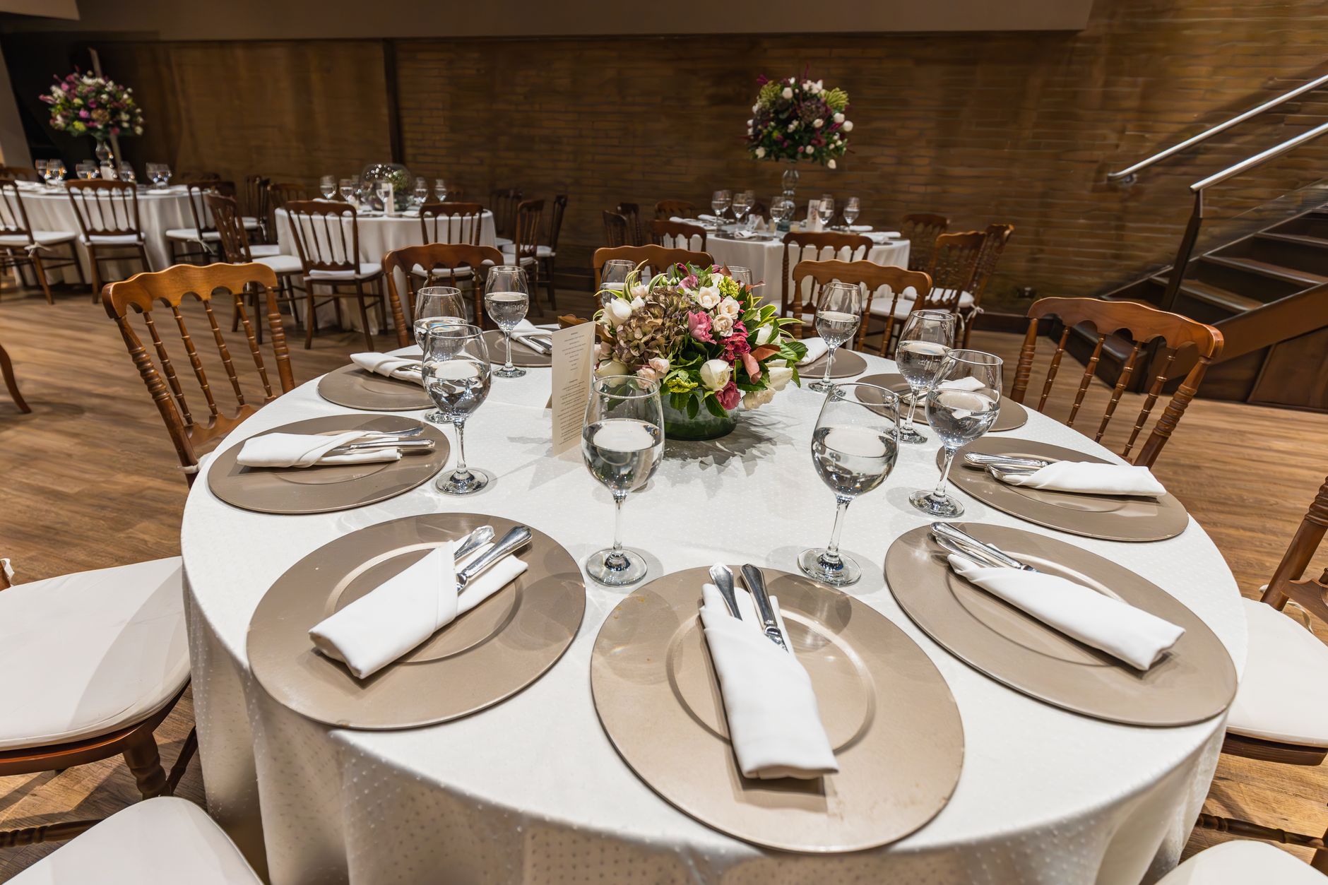 Luxurious table setting for a wedding reception with elegant tableware and floral centerpiece.