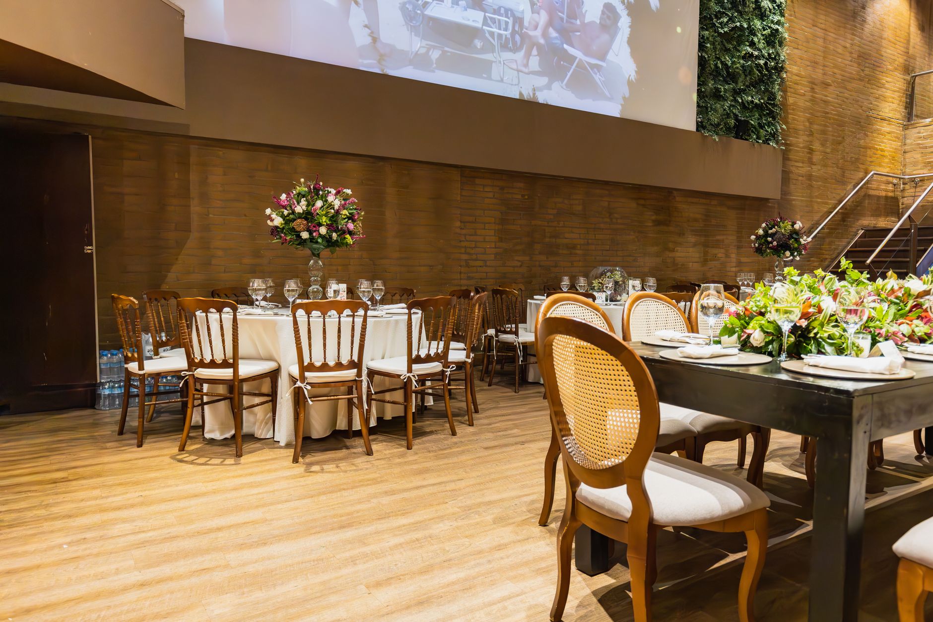 Luxurious indoor wedding reception with floral centerpieces and elegantly set tables.