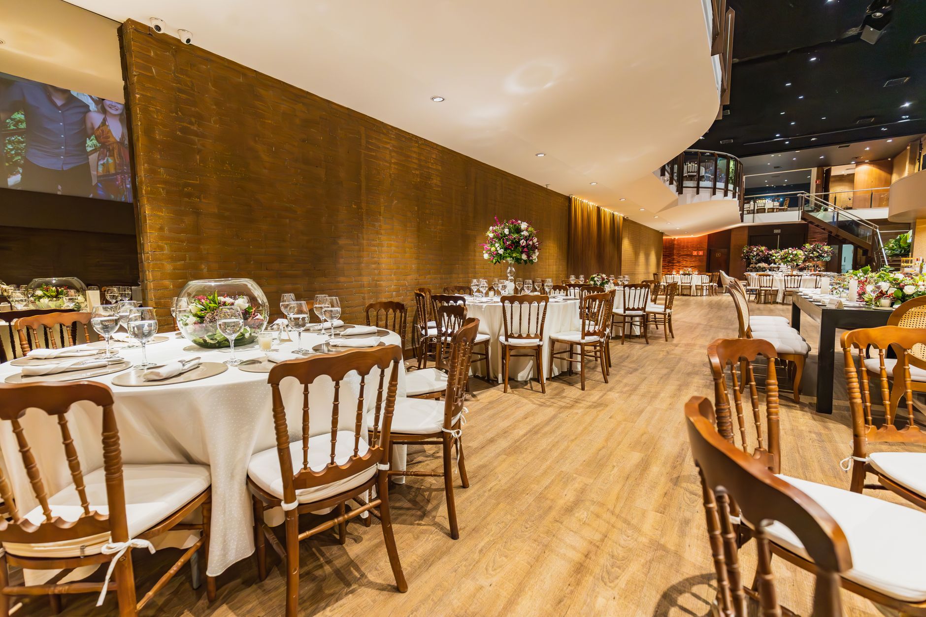 Luxurious wedding reception setup with elegantly decorated tables and chairs indoors.
