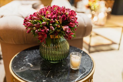 Flowers in Vase on Table near Sofa in Restaurant 