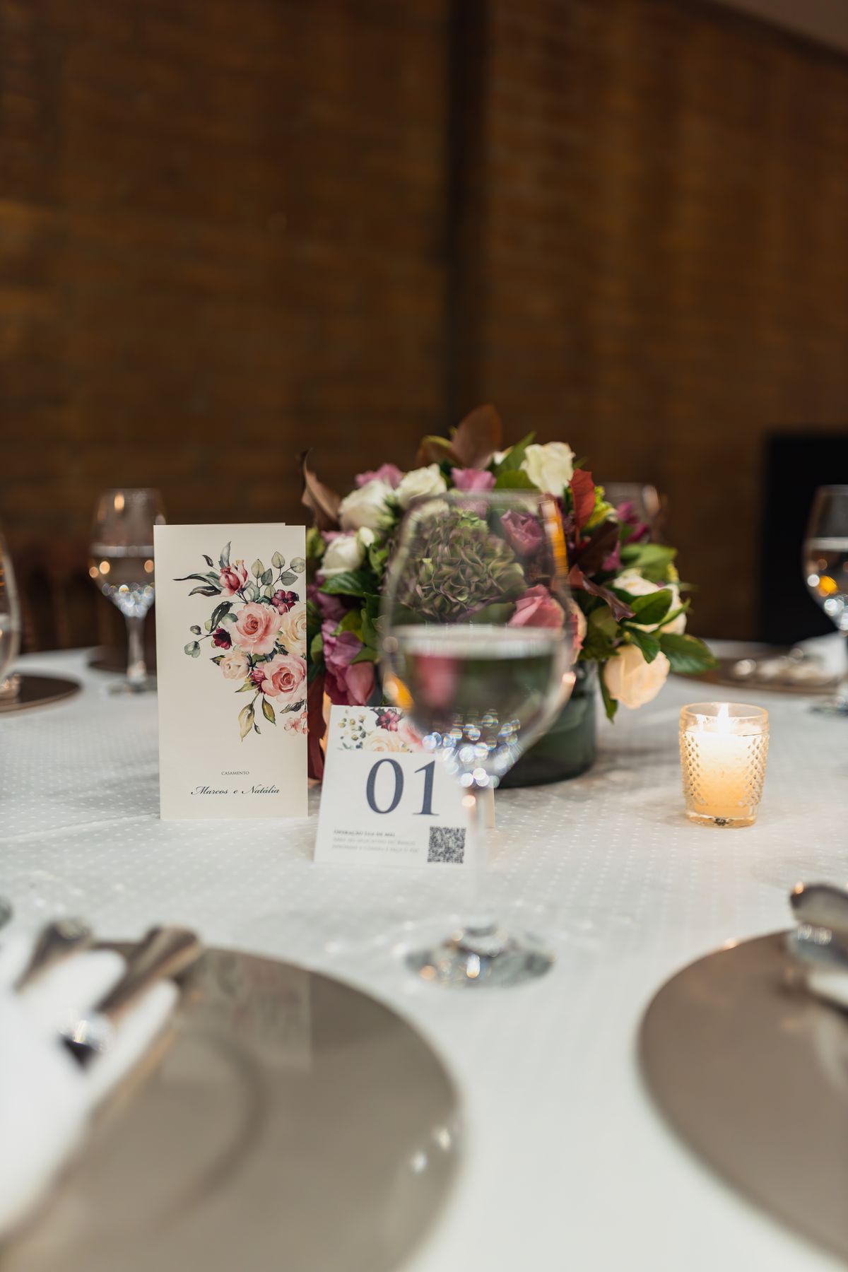 Candlelit reception table set with a floral centerpiece and fine tableware