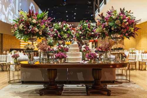 Table with Flower Arrangements and a Wedding Cake