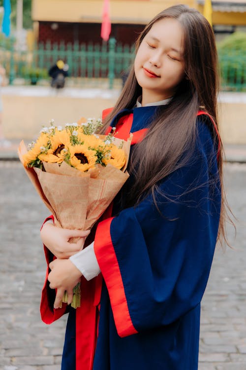 Portrait of Graduate with Flowers and in Gown