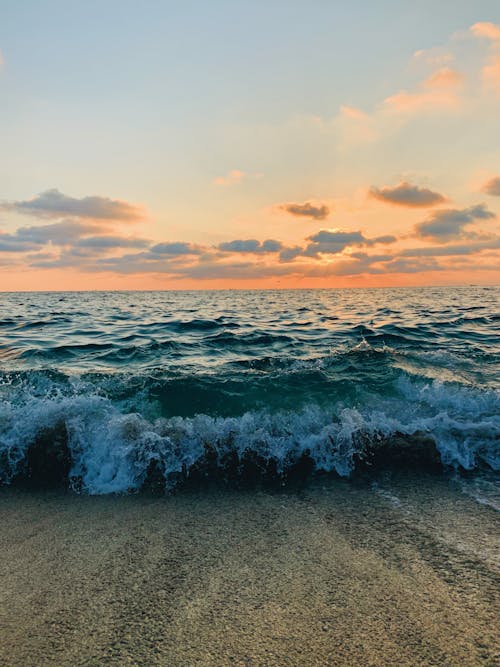 Foto profissional grátis de beira-mar, borrifando, cair da noite