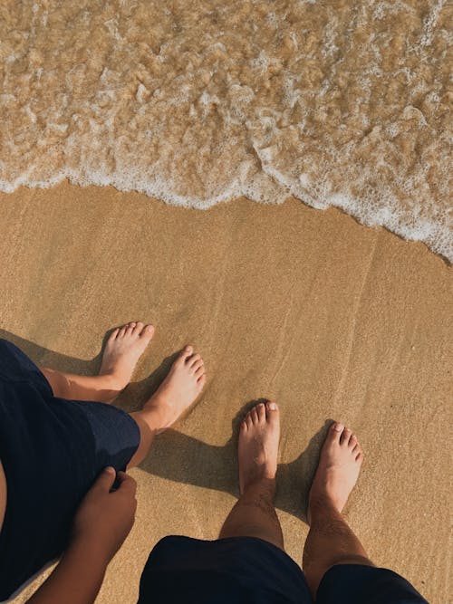 Feet of People Standing on Beach 
