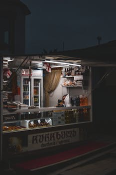A street food stall selling traditional churckhela at night, illuminated in a Georgian city.
