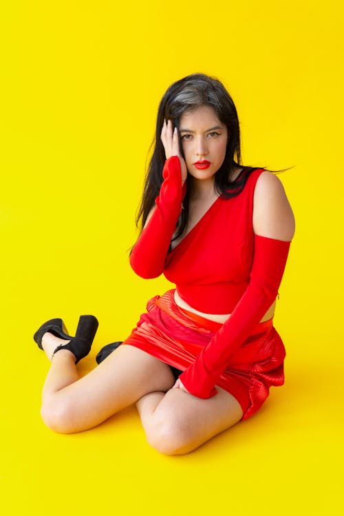 Young Woman in a Red Dress Posing in Studio 