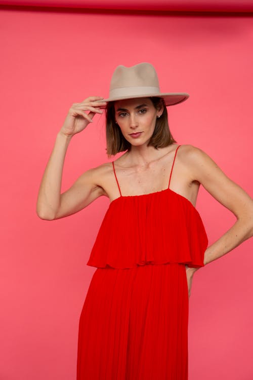 Young Woman in Dress and Hat Posing in Studio