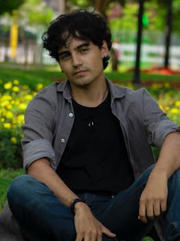 Young man relaxing in a lush green park in Lima, Callao, Perú, during summer.