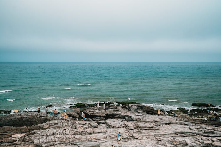 People On A Rocky Beach