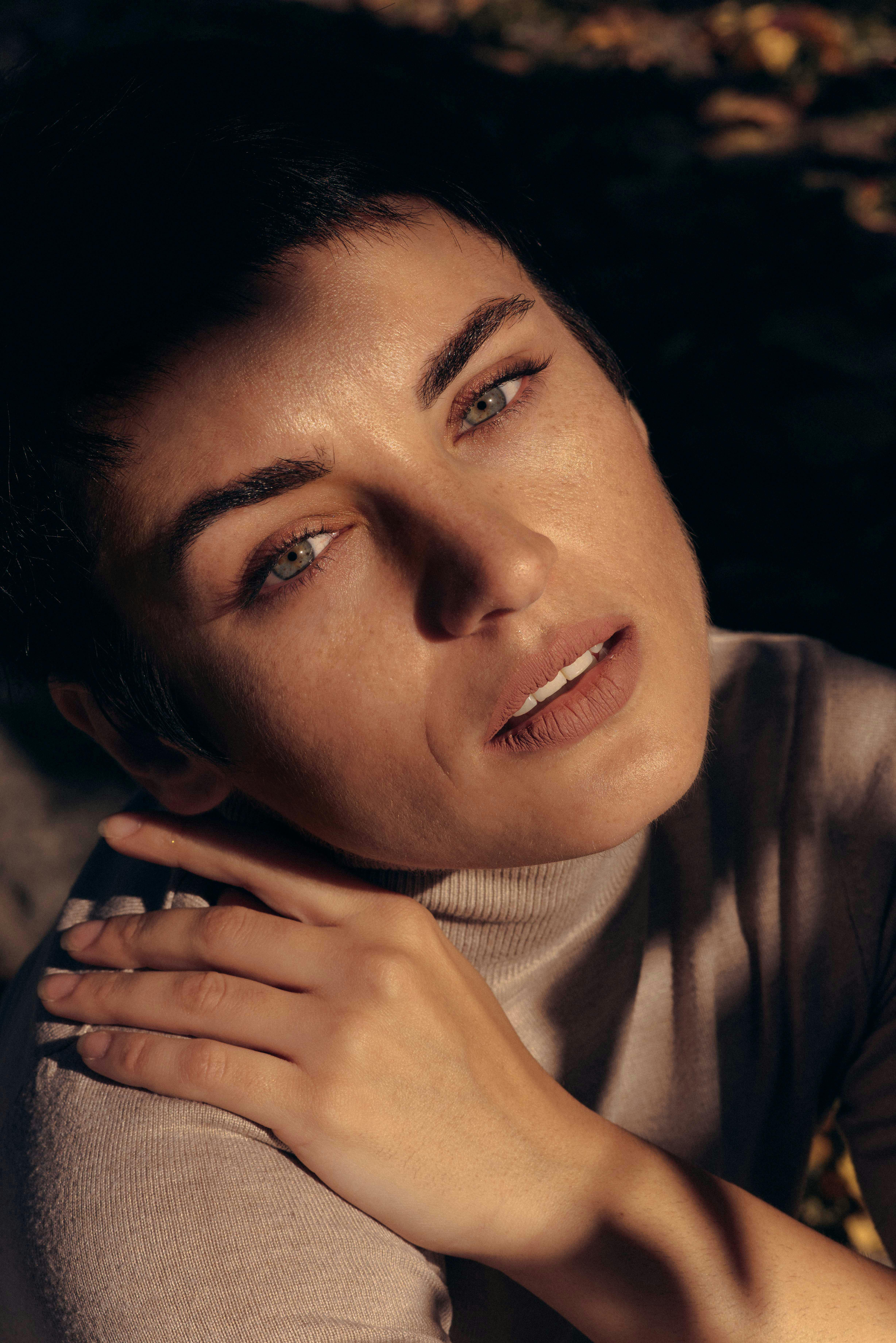 短发女性在自然光下的特写，妆容优雅而微妙