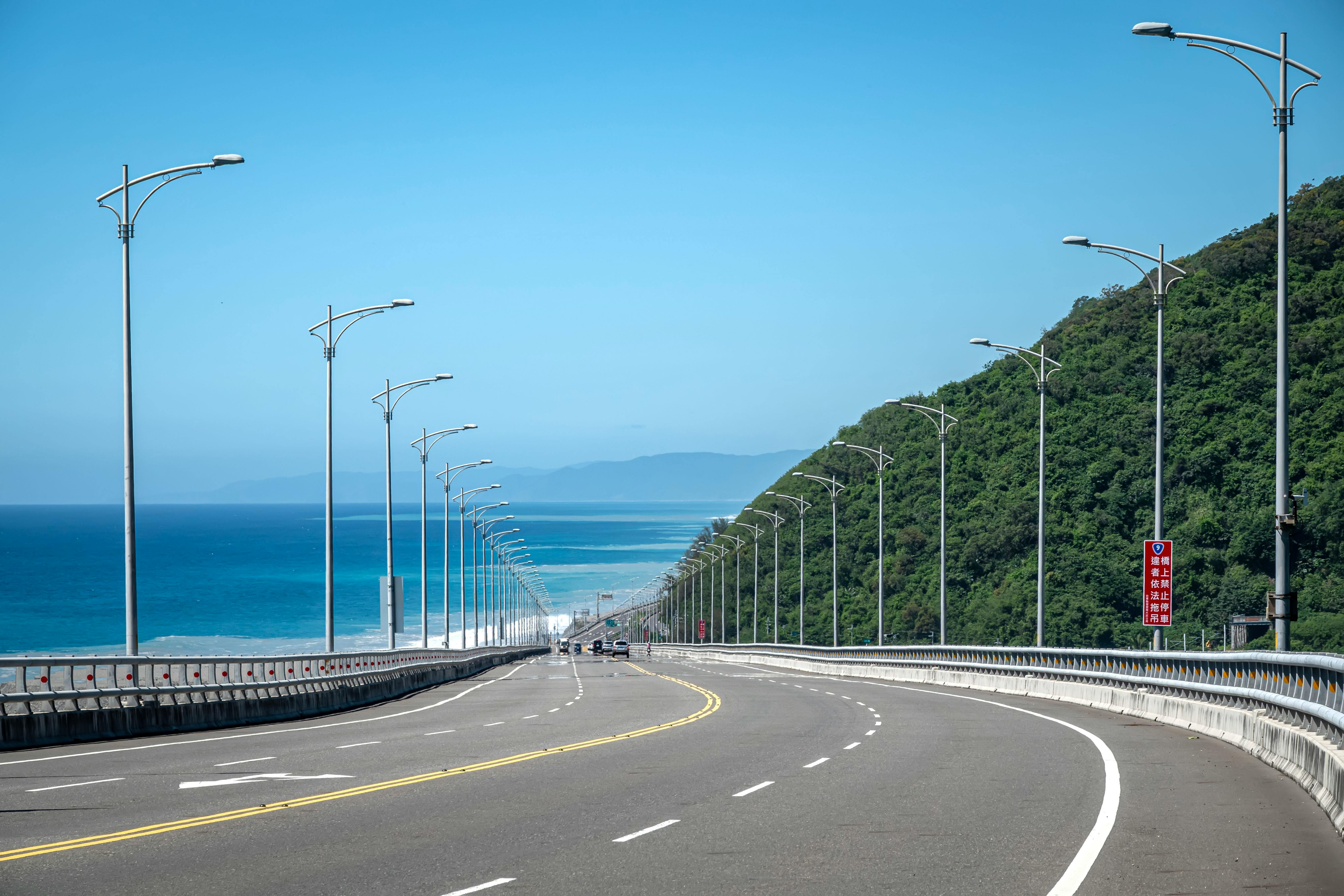 Explore the stunning coastal road in Taitung, Taiwan with lush greenery and ocean views.