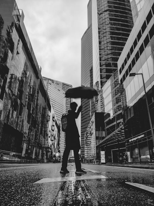 Man with an Umbrella Standing in the City Street 