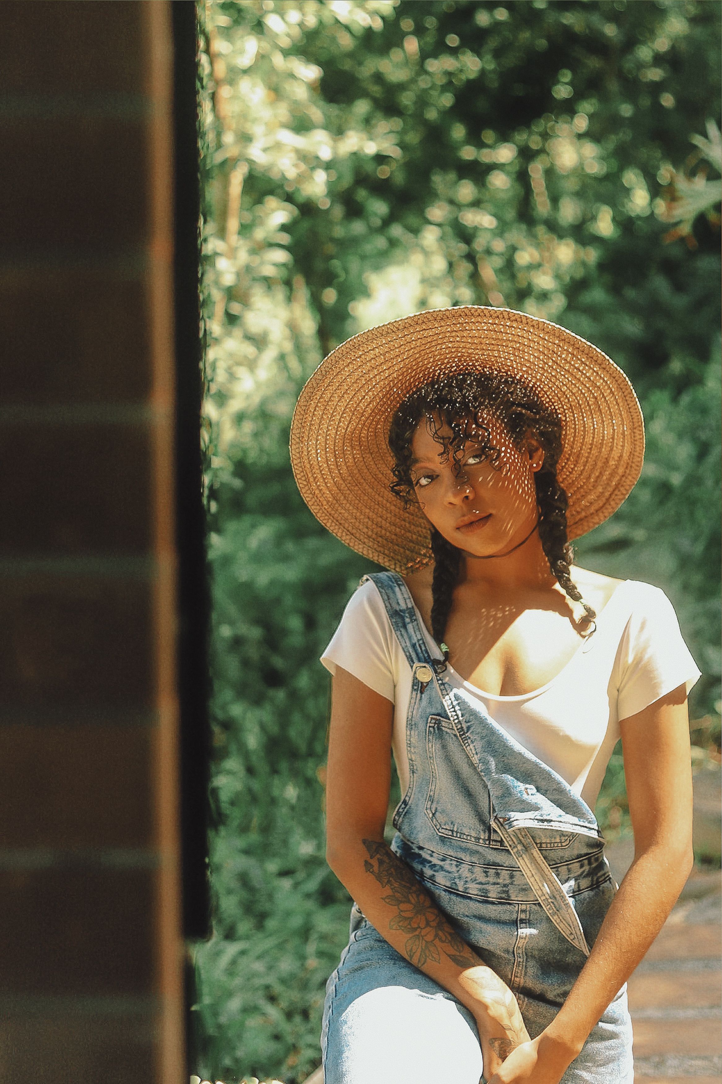 Young Woman in a Straw Hat and Denim Overalls · Free Stock Photo