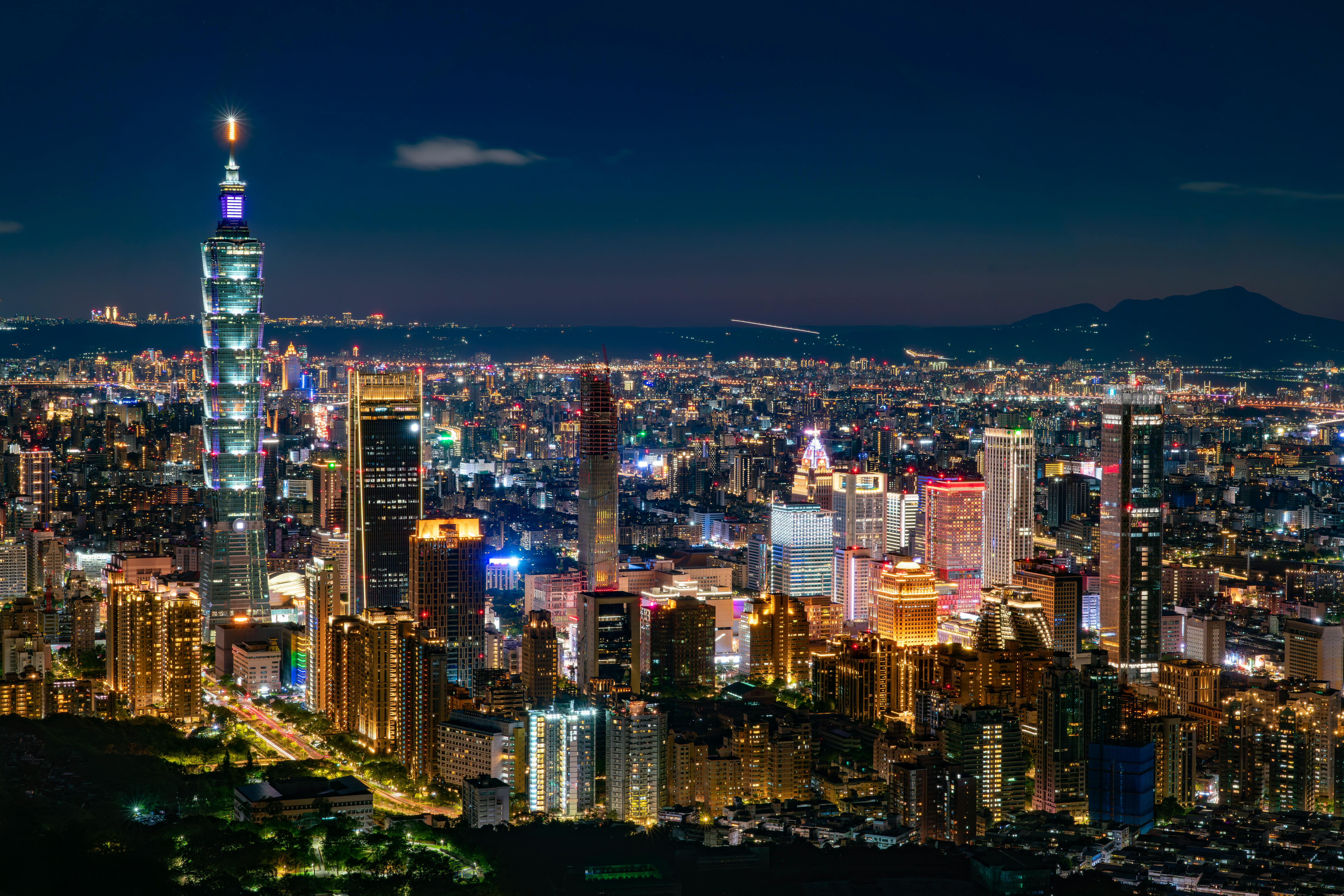 Captivating night view of Taipei cityscape featuring iconic Taipei 101 skyscraper illuminated against the night sky.