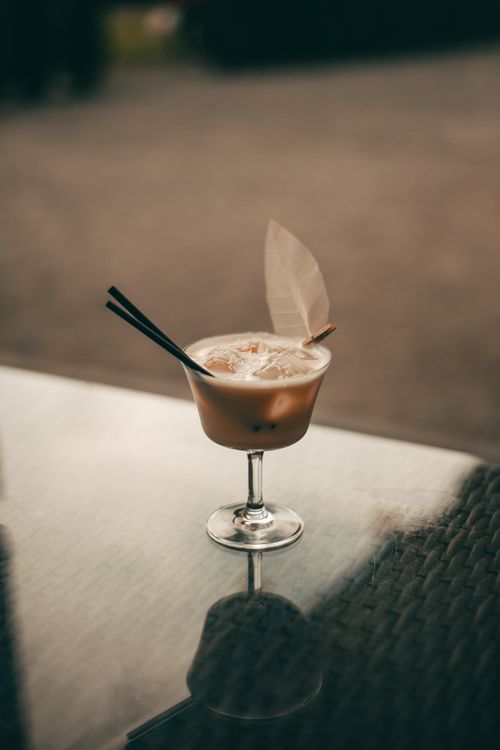 Free Chic cocktail with straws on a reflective table outdoors, exuding elegance. Stock Photo