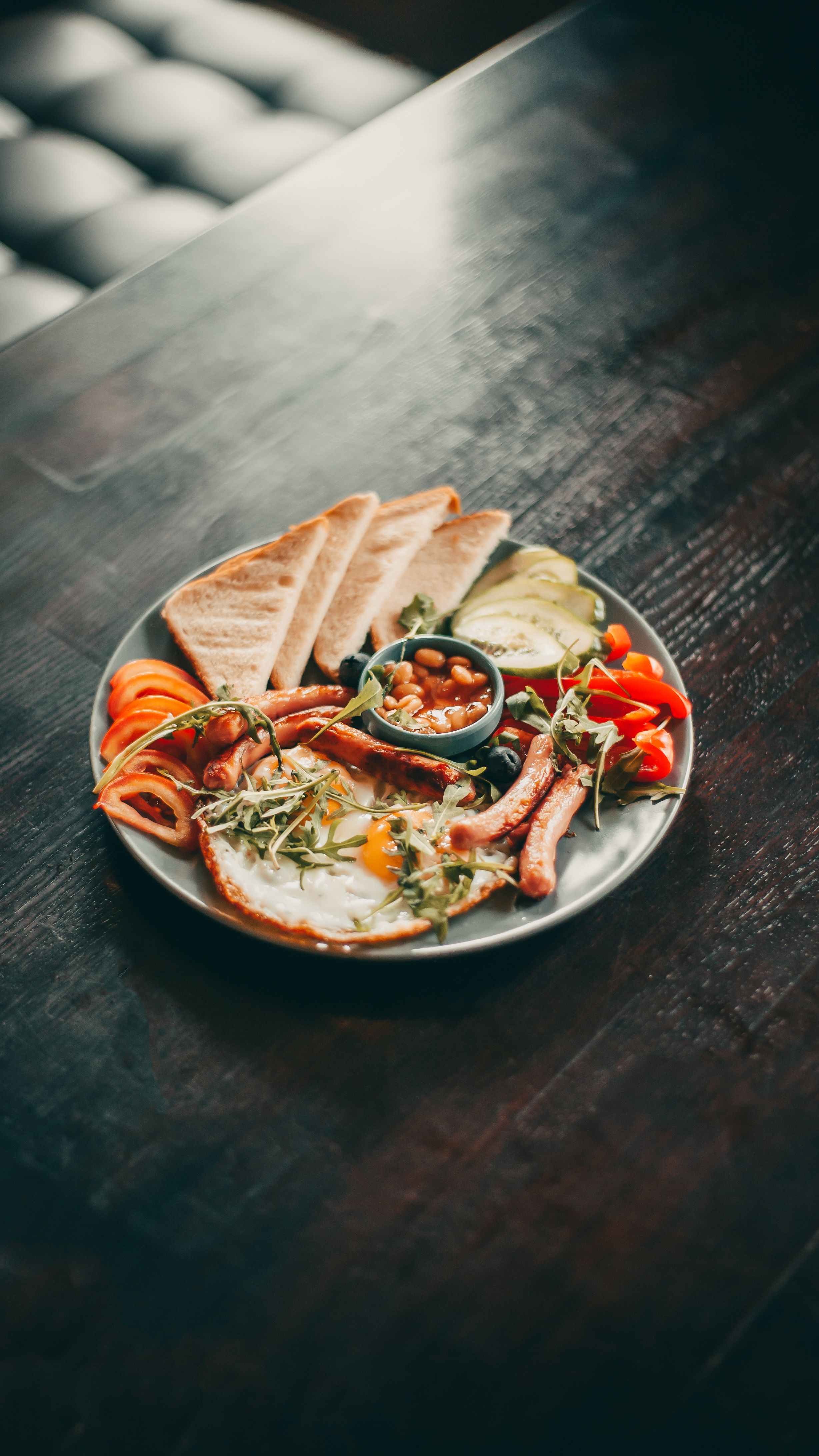 A mouthwatering full English breakfast on a wooden table setting.