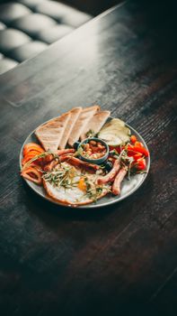 A mouthwatering full English breakfast on a wooden table setting.
