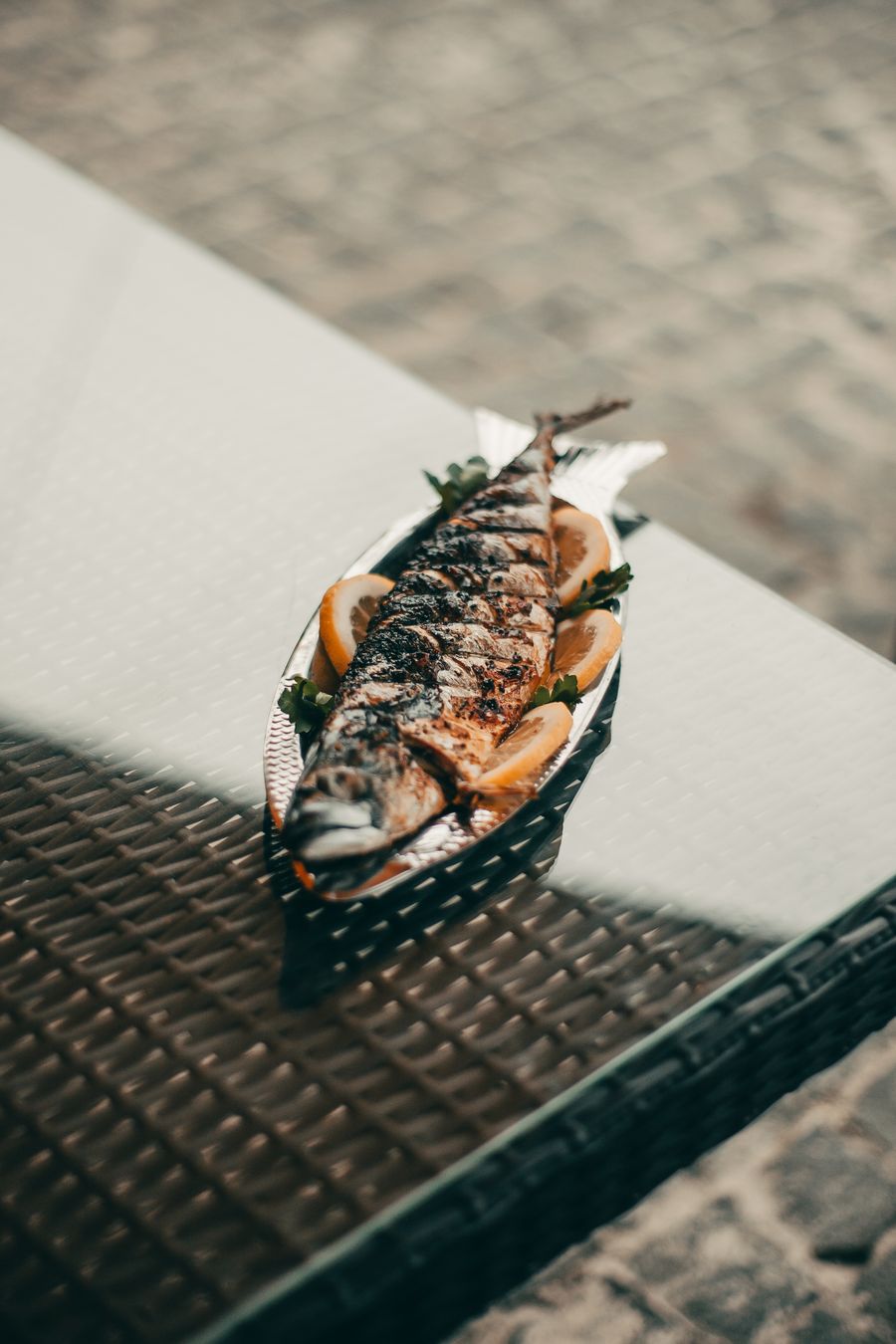 A whole grilled fish with citrus on a platter