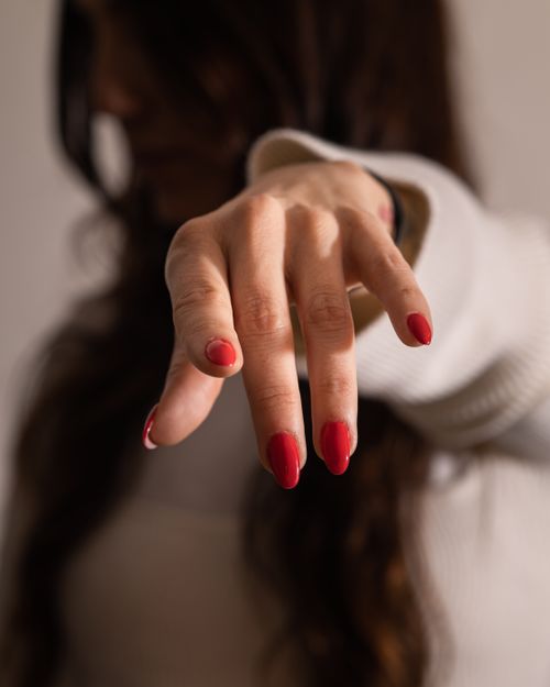Free Elegant close-up of a woman's hand with red nail polish, highlighting a stylish manicure. Stock Photo