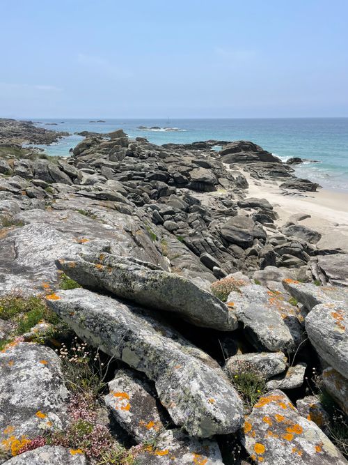 Free Scenic rocky coastline with ocean view, clear blue sky, and rugged terrain. Stock Photo