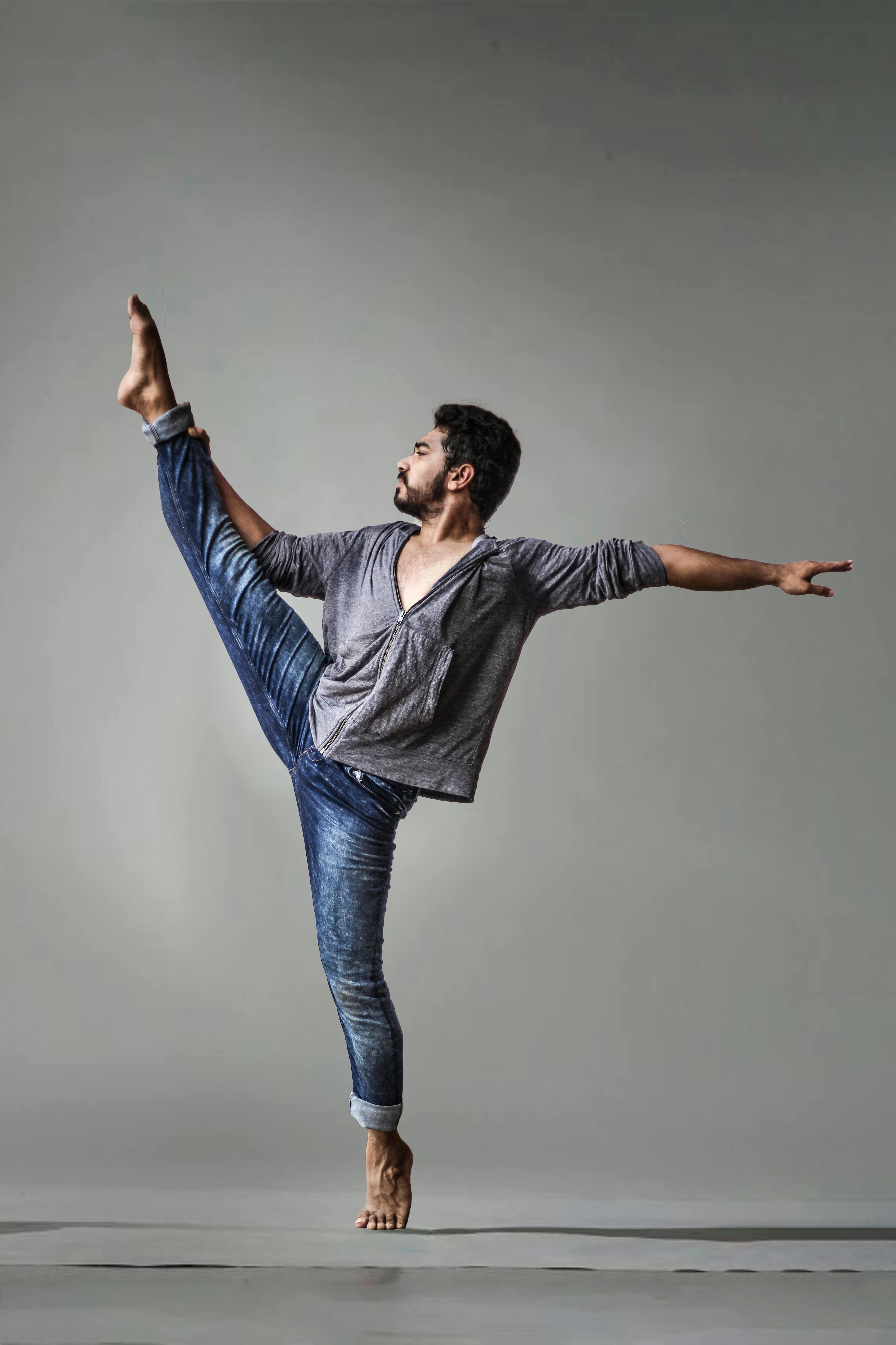 The classic ballet dancer in white tutu posing at ballet barre on studio  background. Young teen