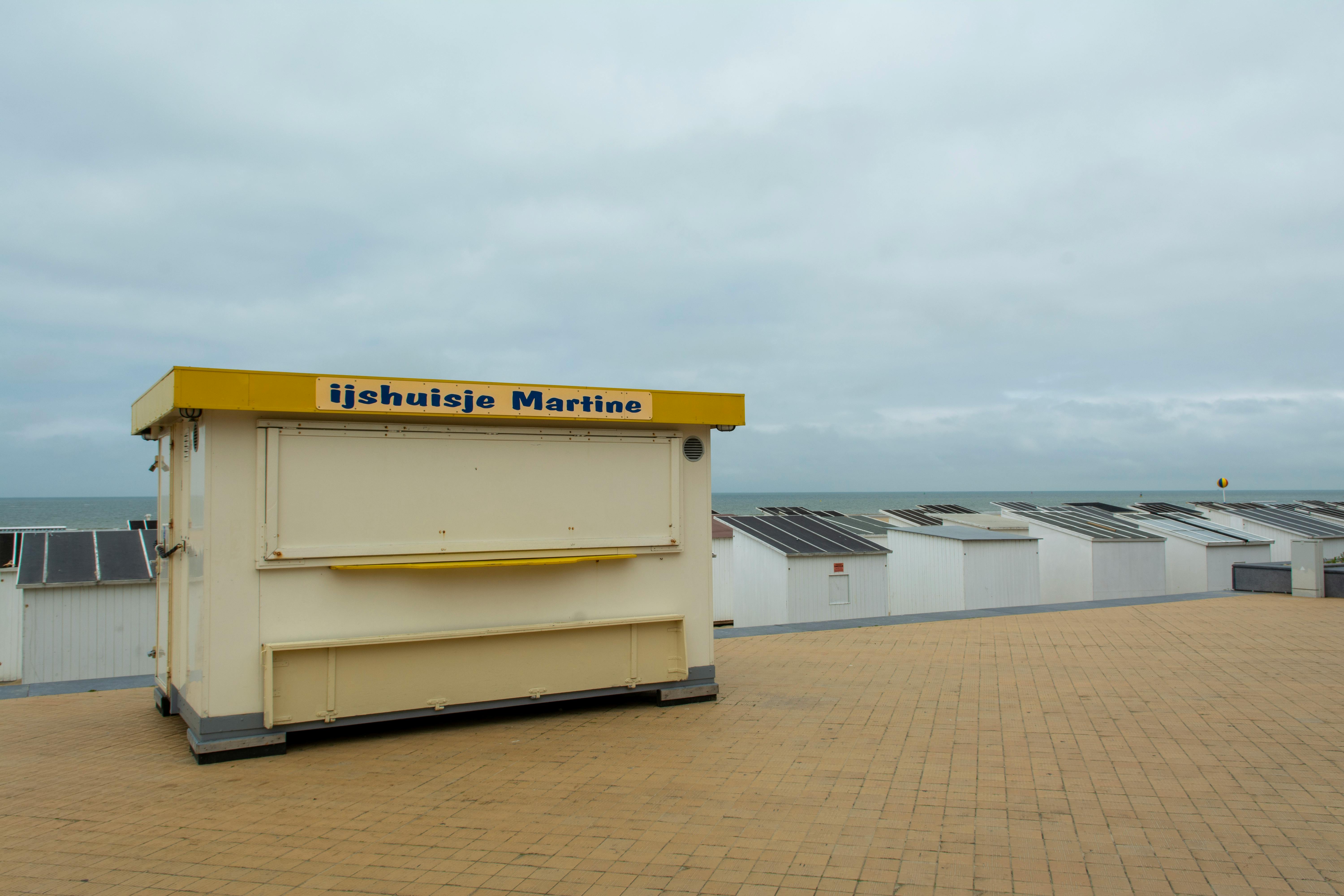 Ice cream stand and beach huts along Oostende's scenic beachfront promenade.