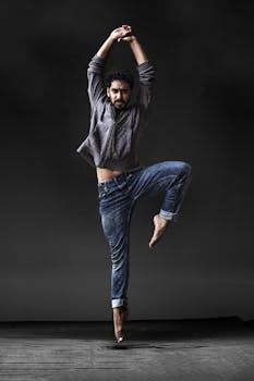 在黑暗背景下，一名男性舞者以戏剧性的当代舞蹈姿势，展现出运动能力与优雅