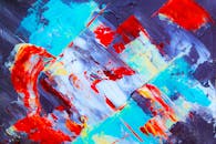 画布上的动态抽象艺术作品，以生动的蓝色、红色和橙色丙烯酸笔触呈现