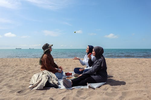 Free Women Having Fun at a Picnic by the Sea Stock Photo