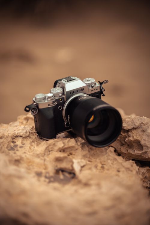 Free Close-up of a vintage camera placed on a rocky surface, capturing a rustic vibe. Stock Photo