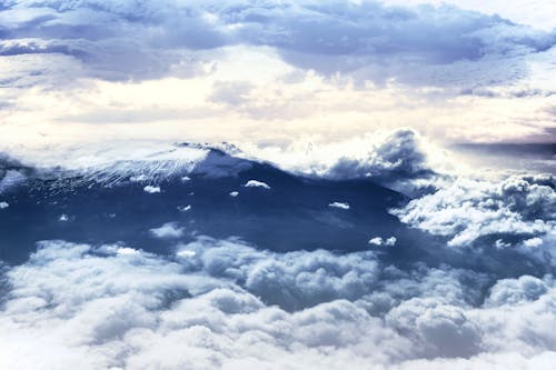 Snowed Mountain Peak among Amazing Clouds