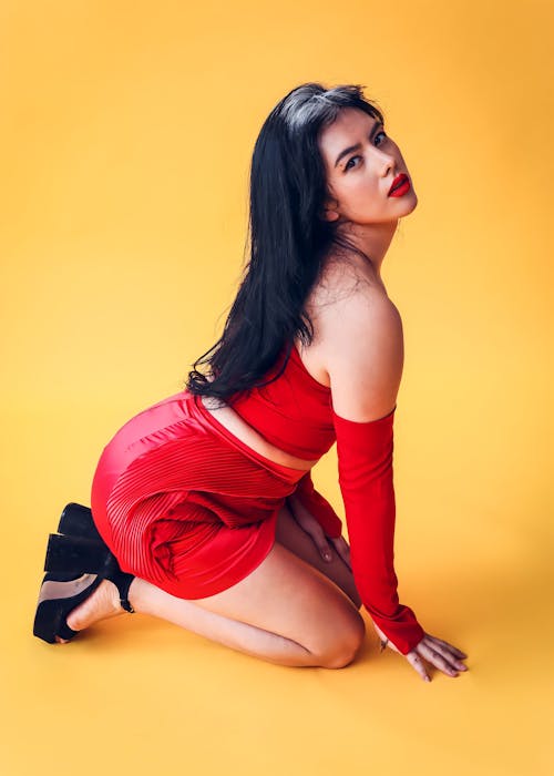 Young Woman in a Red Dress Kneeling on the Floor 