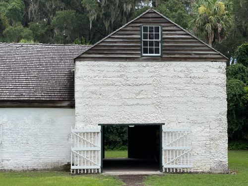 Free Historic white barn with open double doors in a rustic rural setting. Stock Photo
