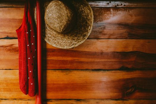 A straw hat and red cloth hang on a rustic wooden wall, creating a cozy interior aesthetic.