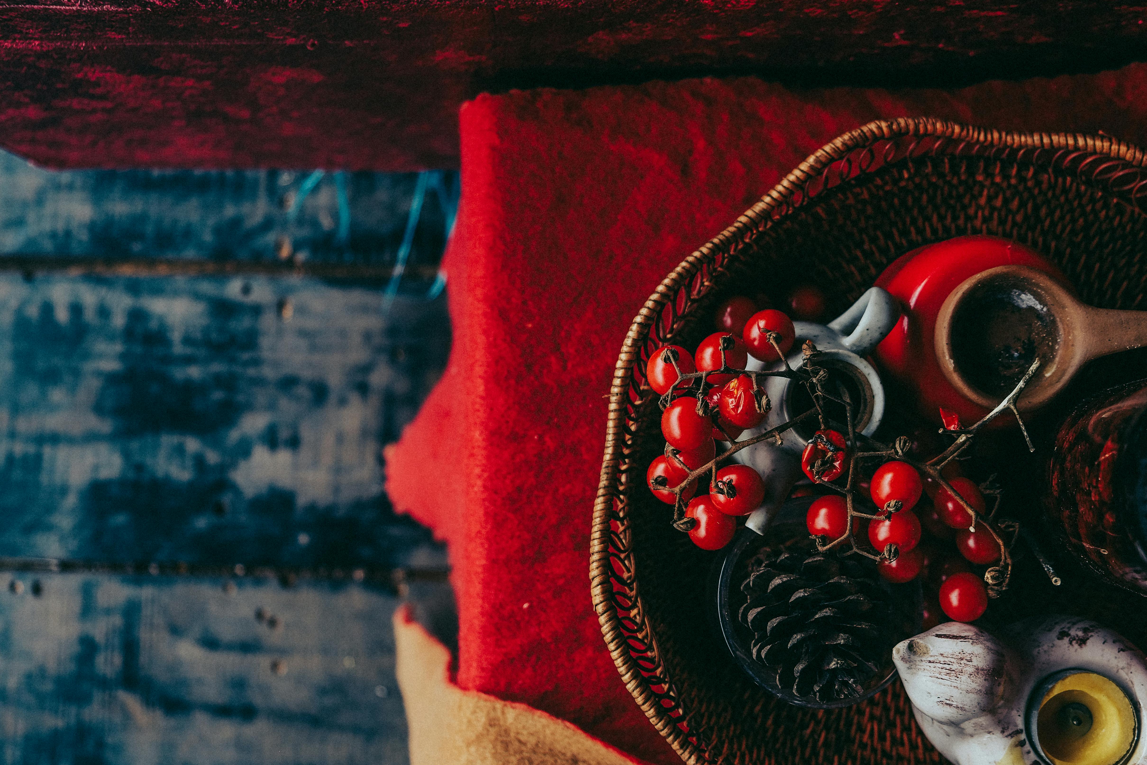 乡村木地板上，装饰篮里装着红色浆果、松果和度假用品