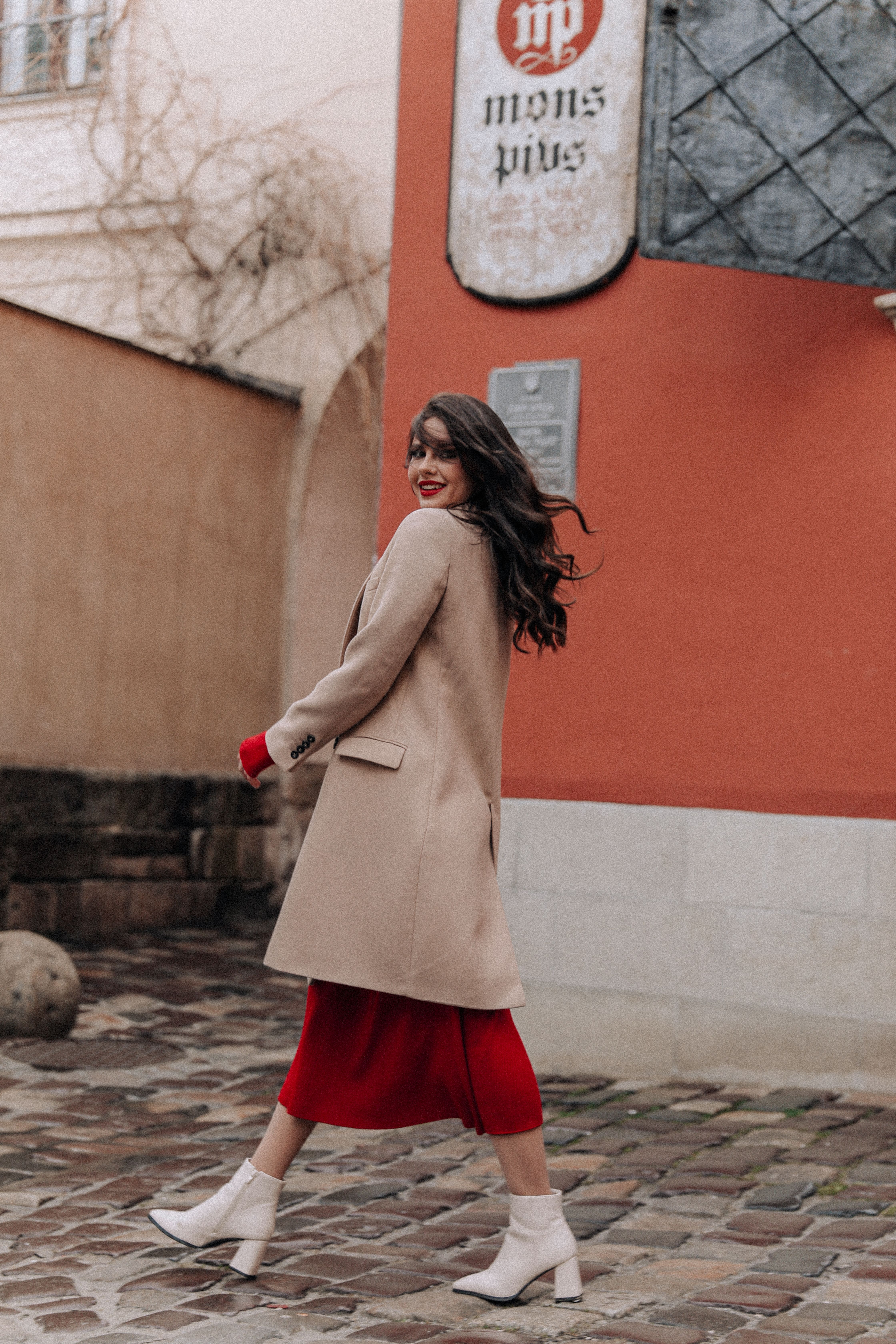 Woman in a Coat and Red Dress Walking in a City  Free Stock Photo