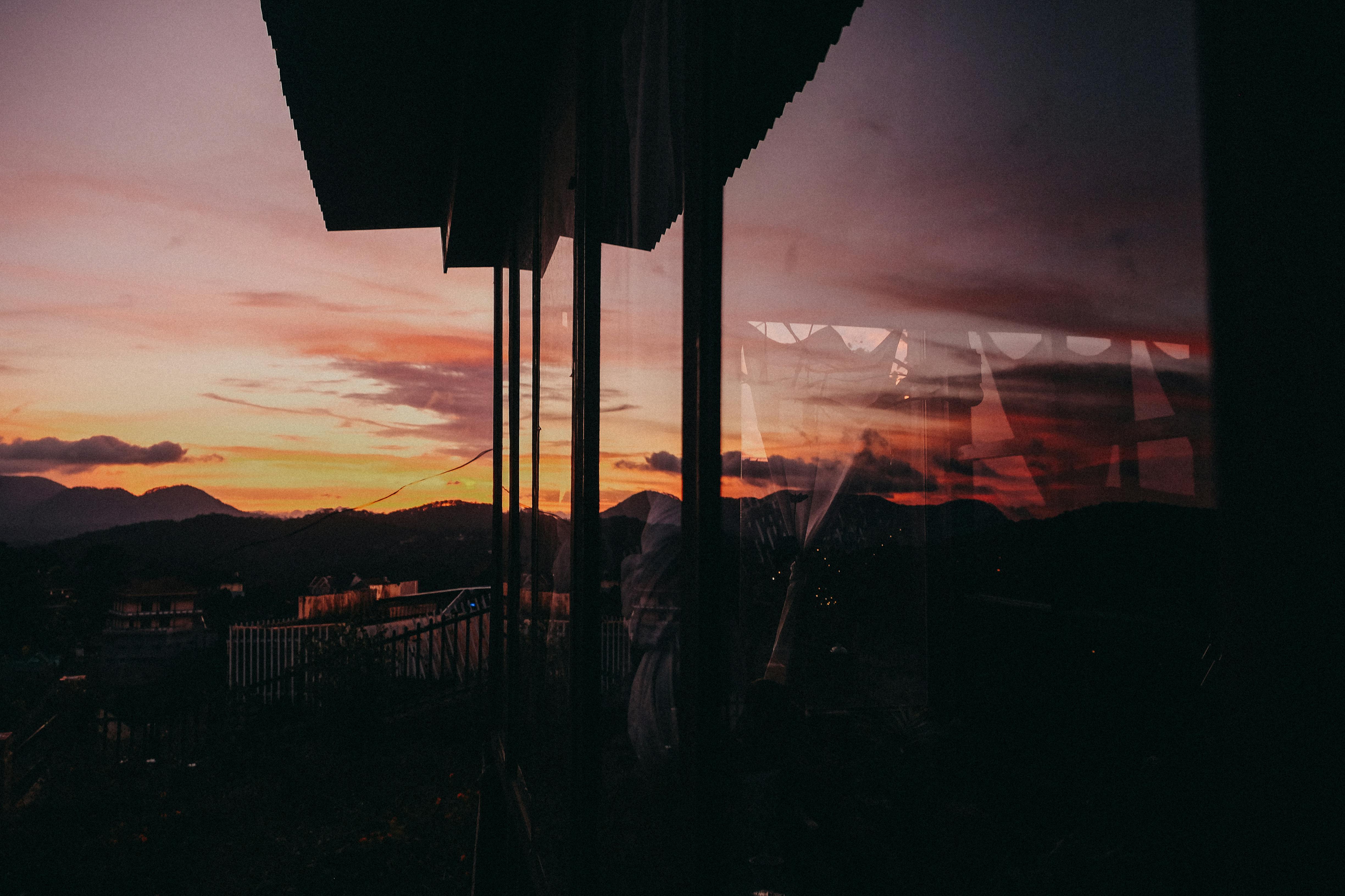 美丽的日落与山脉映在窗上，营造出温暖而宁静的氛围