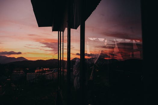 美丽的日落与山脉映在窗上，营造出温暖而宁静的氛围