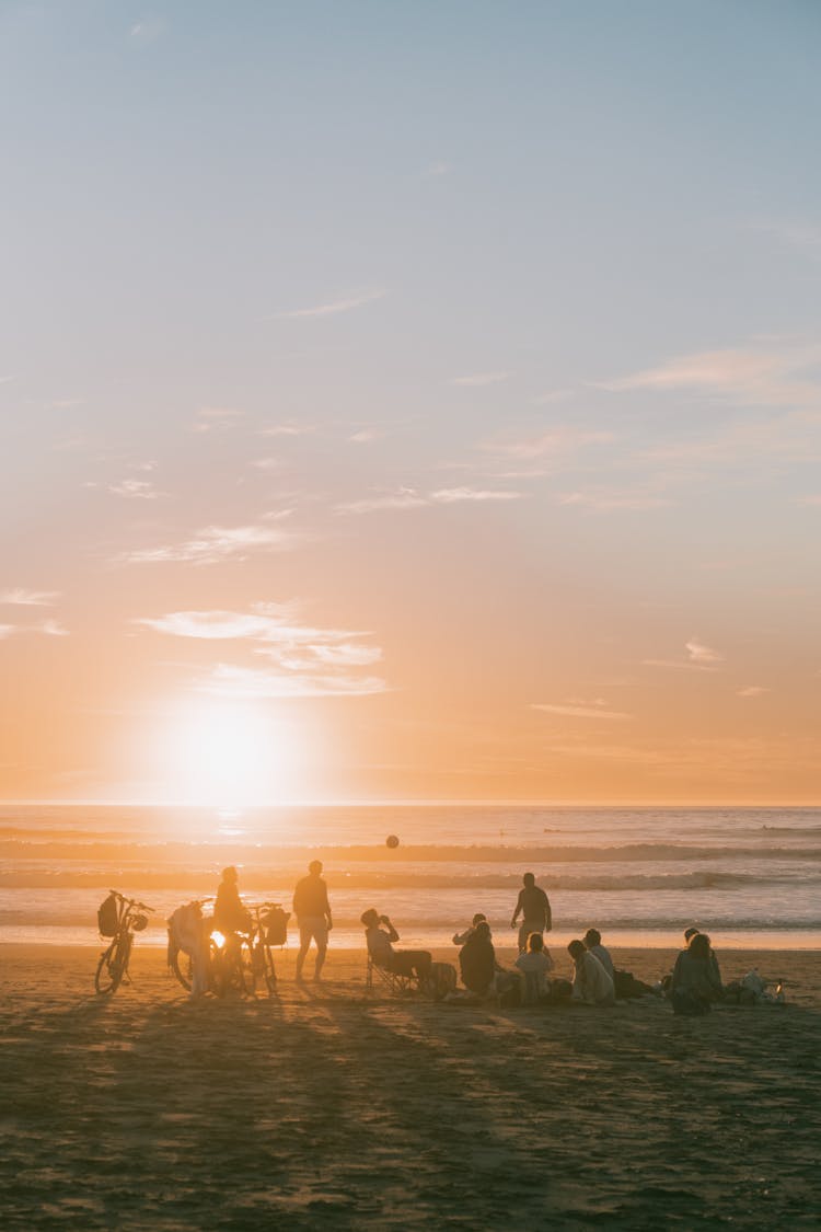 A Group Of Friends On The Beach At Sunset 