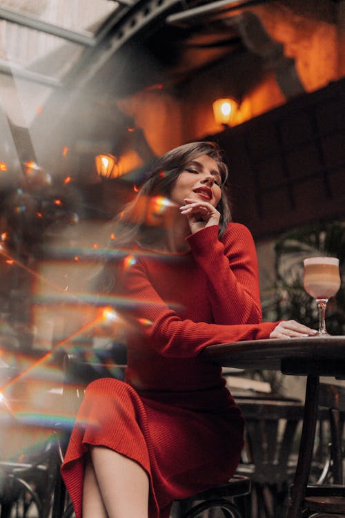 Woman in Red Dress Sitting at Restaurant