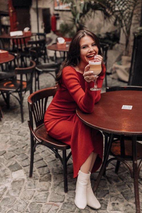 Free Young Woman Sitting at a Restaurant Table and Drinking Coffee  Stock Photo