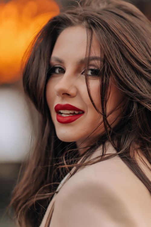 Free Elegant portrait of a smiling brunette woman in outdoor setting, exuding sophistication and poise. Stock Photo